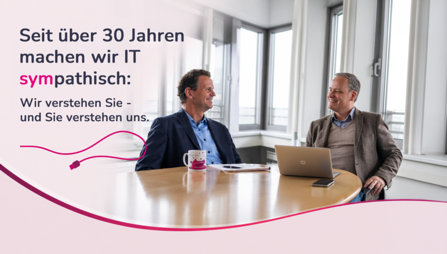 Zwei Männer im Büro, lächelnd.