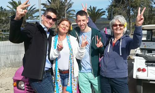 Vier Personen posieren mit Peace-Zeichen.